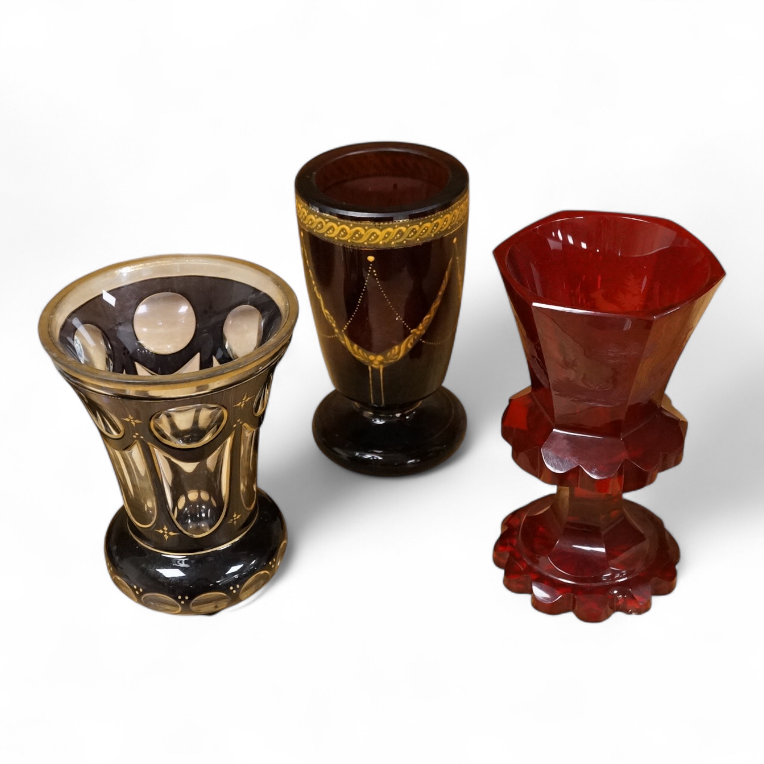 A 19th century Bohemian engraved ruby glass goblet, a similar amethyst and clear overlaid glass vase and an enamelled amethyst glass goblet, largest 15cm high
